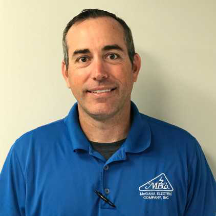 A man in blue shirt standing next to wall.